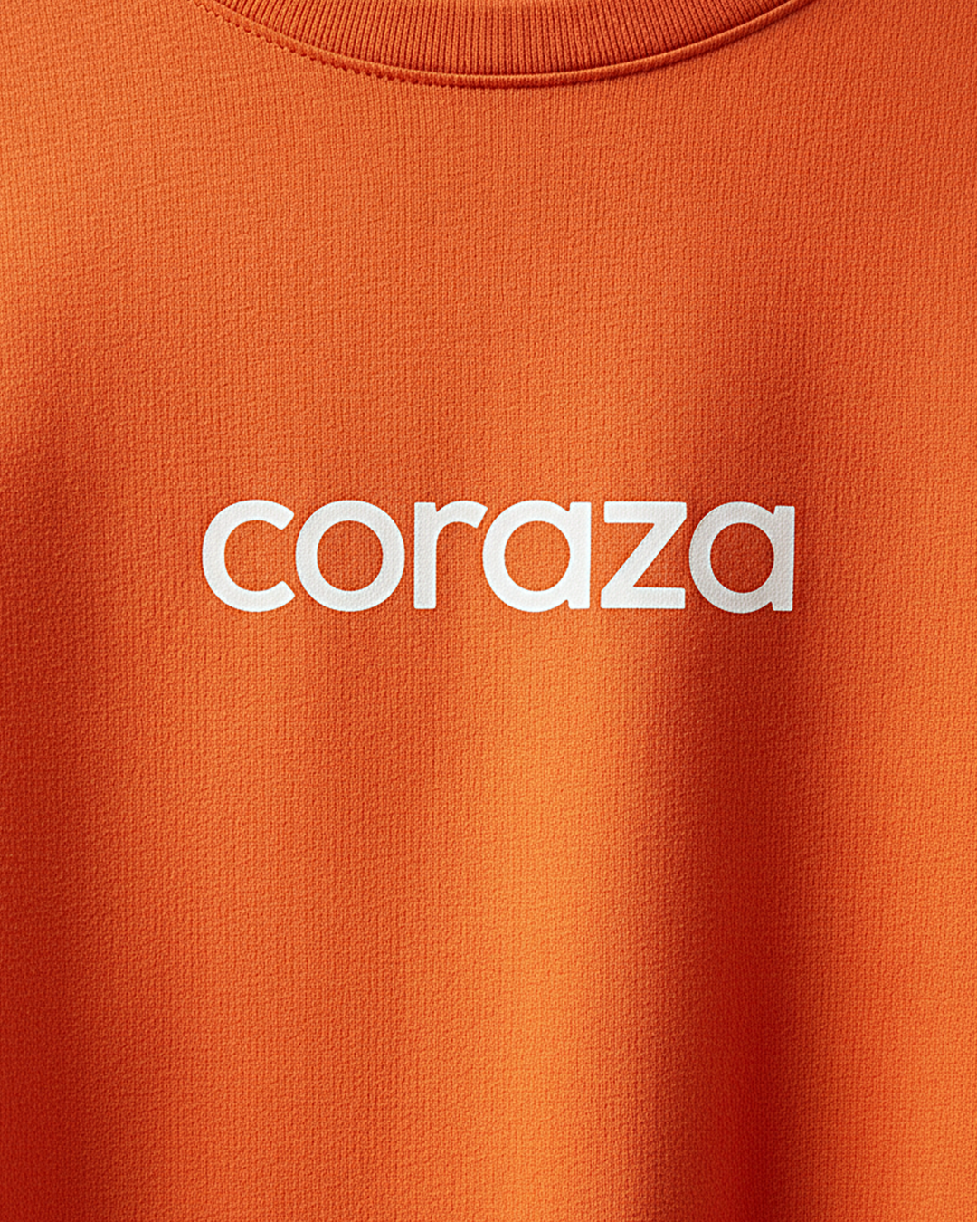 Primer plano de camiseta naranja básica con logo Coraza en el pecho